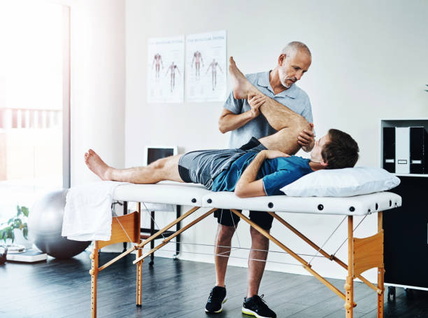 male physical therapist during a physical therapy session with his male patient hired by a physical therapy staffing agency